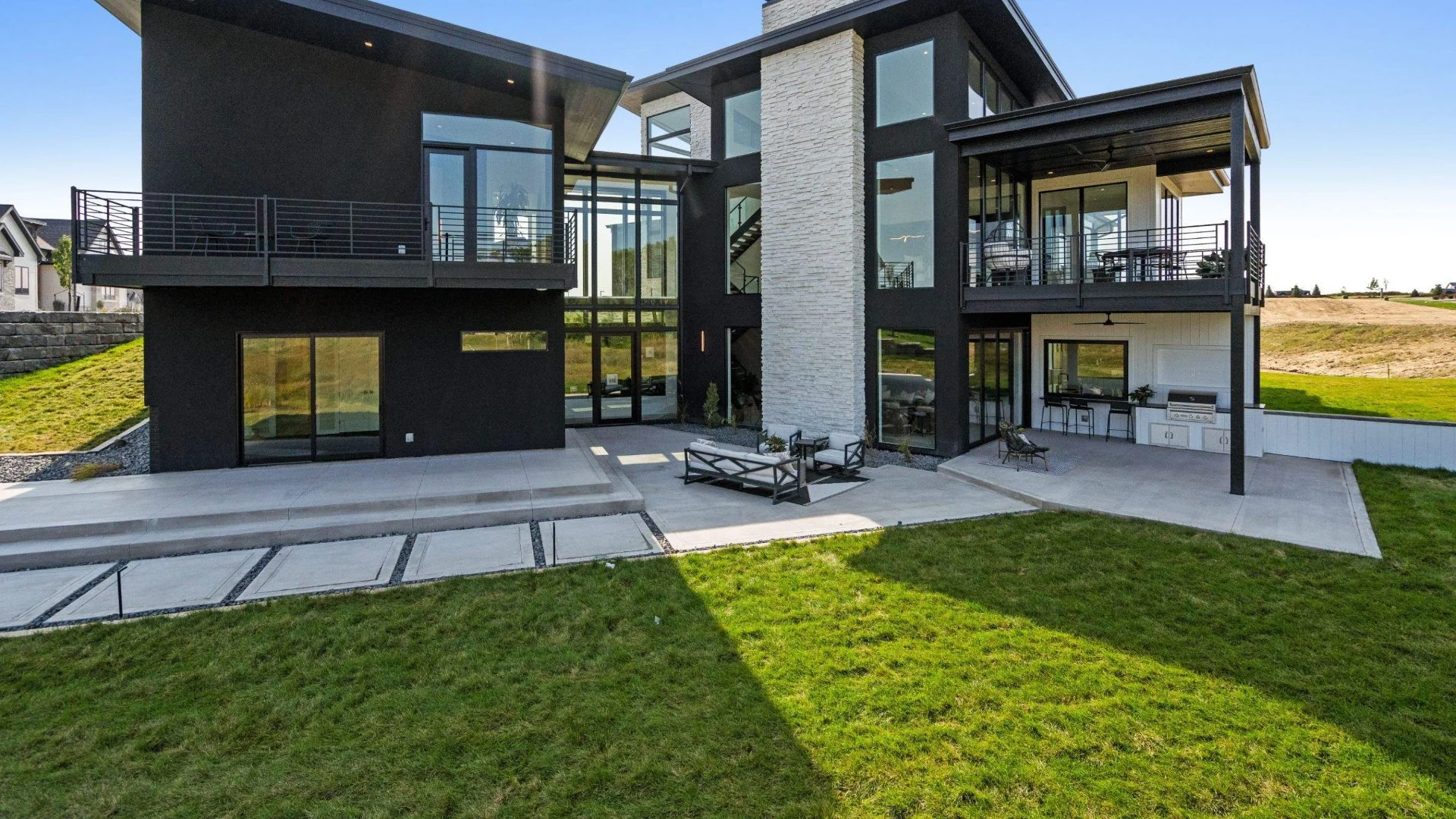 Modern black house with a spacious concrete patio area in Iowa City, IA