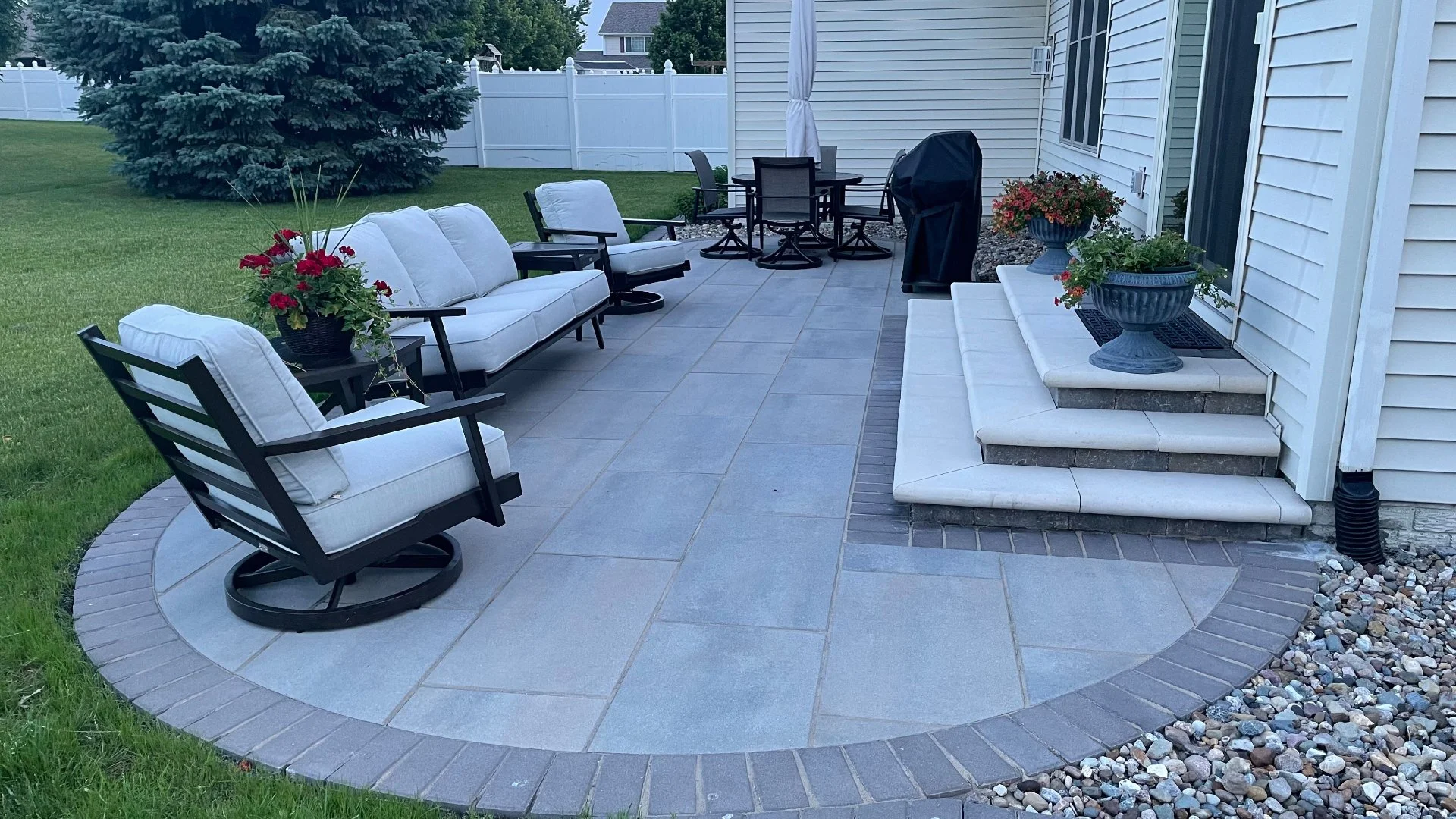 A cozy outdoor seating area with comfortable chairs and potted flowers, creating a perfect relaxation spot in Ankeny, IA.