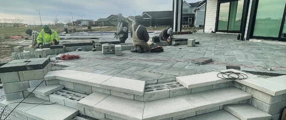 Professionals building a patio in Ankeny, IA, using pavers.