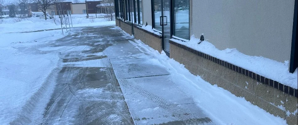 Snow-cleared sidewalk along a commercial building in Ankeny, IA.