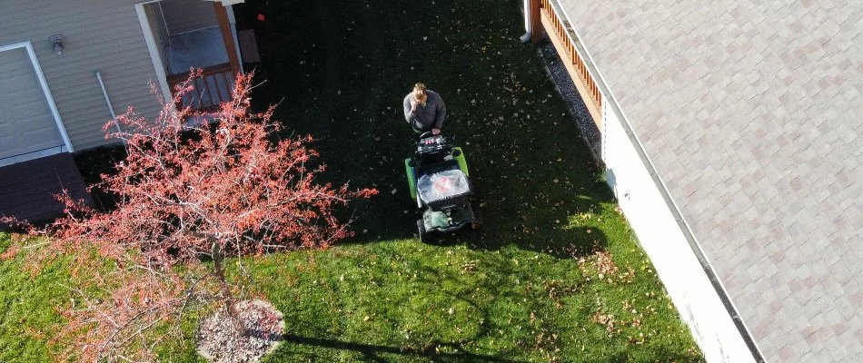 Tech in Ankeny, IA, applying granular fertilizer on grass.