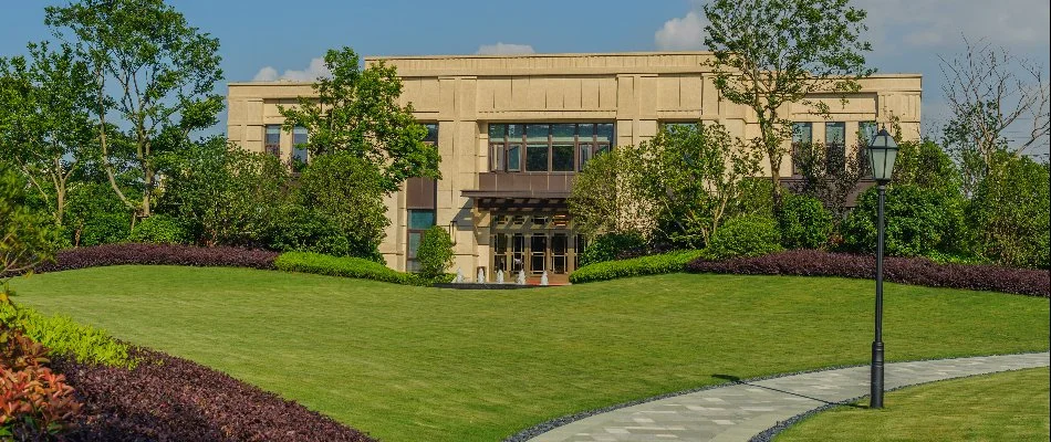 Trees and shrubs on green grass by a commercial property in Ankeny, IA.