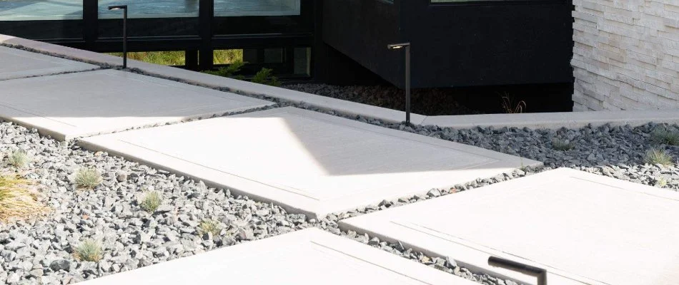 Concrete walkway in Johnston, IA, with rocks and lighting.