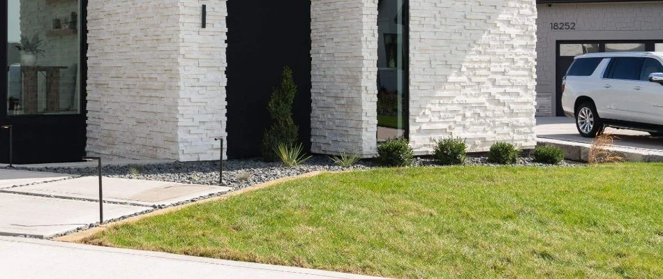 Landscape along a house in Johnston, IA, with plants and rocks.