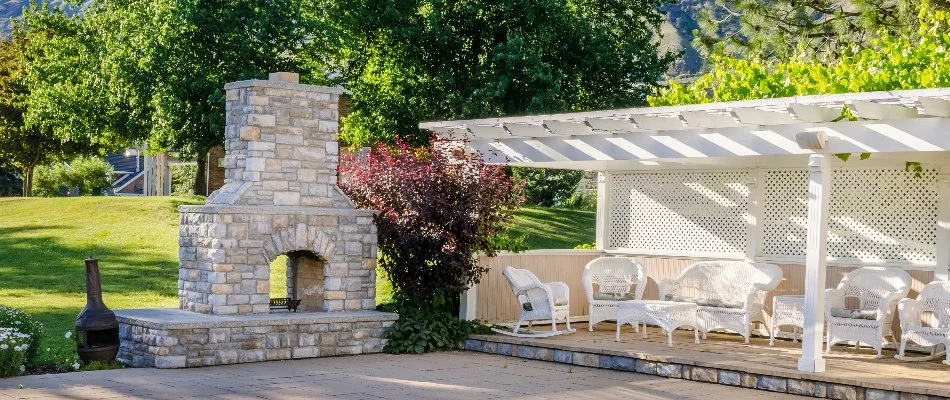 Outdoor fireplace next to furniture and pergola in Ankeny, IA.