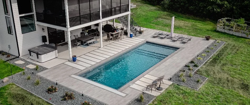 Rectangular pool in Waukee, IA, with a pool deck in a backyard.