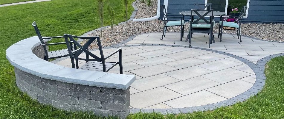 Seating wall along a circular patio in Urbandale, IA, with chairs.