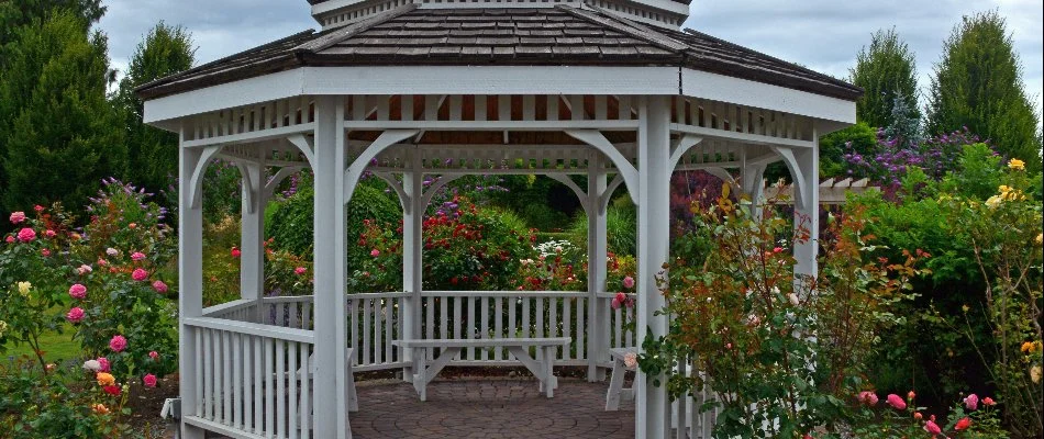 A white gazebo in Ankeny, IA, surrounded by flowers.